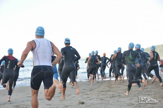 Atletas largam e correm para o mar, para a primeira etapa do triatlo de Caiobá, litoral do Paraná
